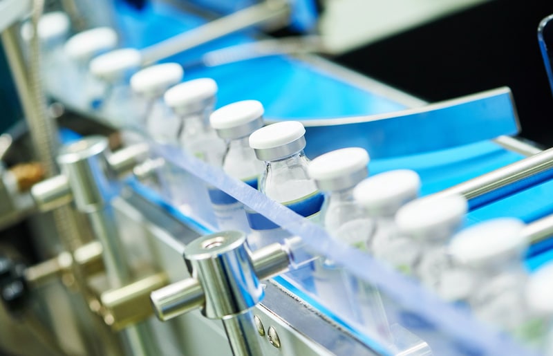 Medical Pharmaceutical drugs being produced with vials on a conveyor machine
